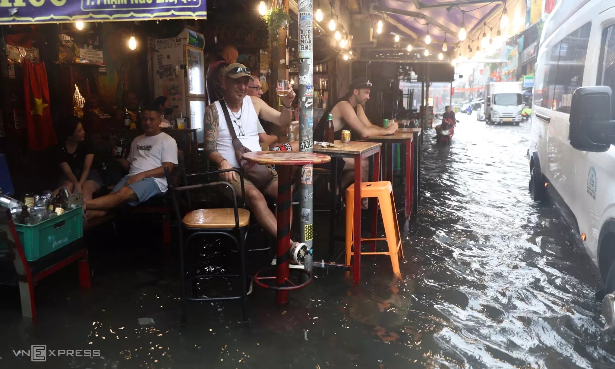 Hình minh họa: Du khách đổi lịch trình, trú chân quán cà phê khi TP HCM mưa lớn